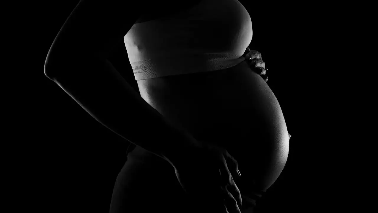 Silhuett av en gravid kvinna som håller sin mage. Bilden kan associeras med vena cava syndrom, en risk under graviditet.
