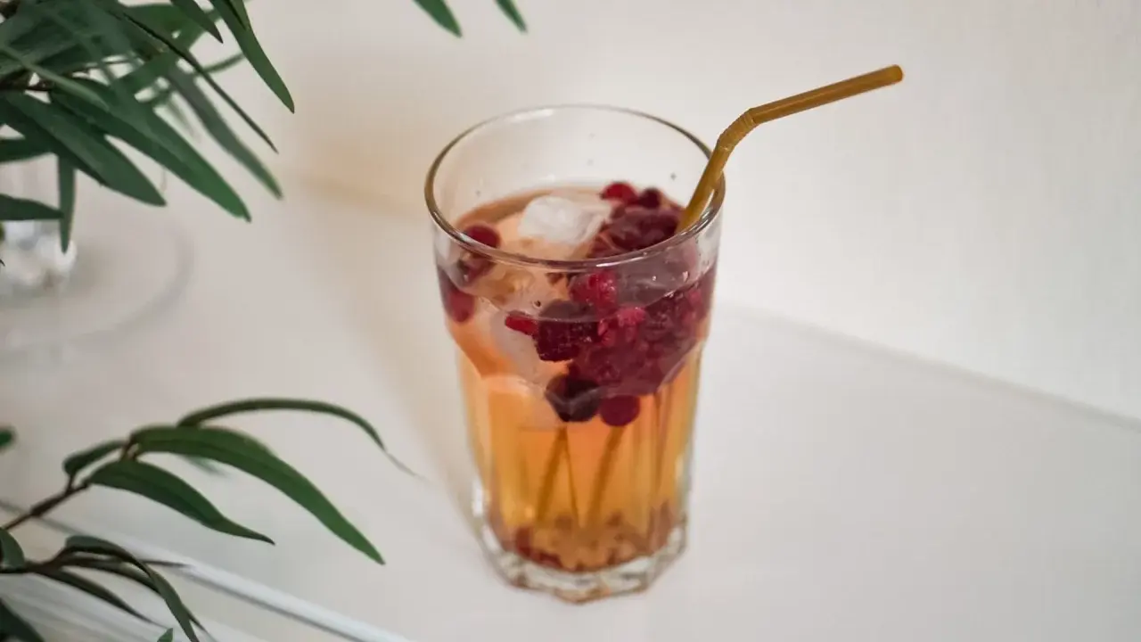 Ett glas med hallonbladste, is och bär. Perfekt för en gravid som vill ha något uppfriskande.