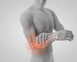 En anatomisk illustration visar muskler i underarmen med en röd cirkel som indikerar smärta.