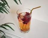Ett glas med hallonbladste, is och bär. Perfekt för en gravid som vill ha något uppfriskande.