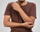 Man håller om sin armbåge, där den mediala epikondylen kan kännas öm.
