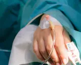 En hand med droppslang, en påminnelse om en misslyckad tvt-operation.