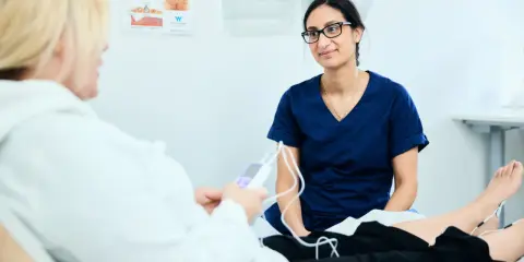 Läkare undersöker en patient med elektroder på benen. Bilden visar en situation där tjejer som kissar på sig kan få hjälp.