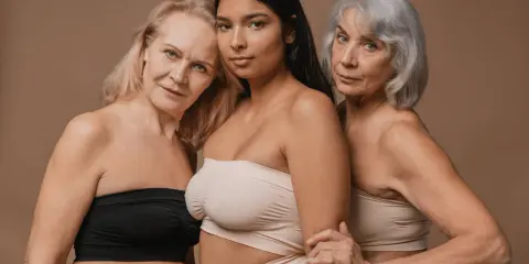 Tre kvinnor i olika åldrar, en ung och två äldre, poserar tillsammans. Frågan "kan man bli gravid i klimakteriet" kan dyka upp när man ser dem.
