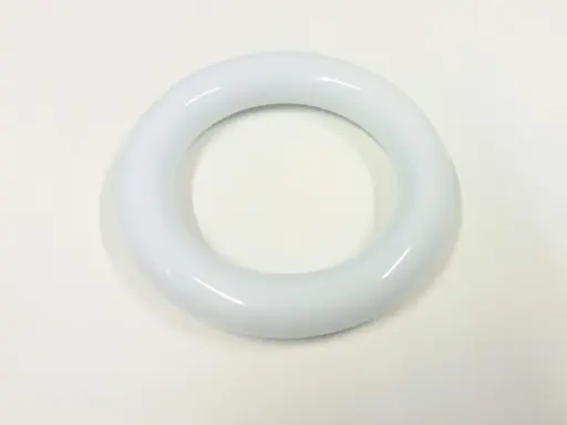 En vit, glansig prolapsring ligger på en ljus bakgrund. Den är rund och har en tjock, slät yta.