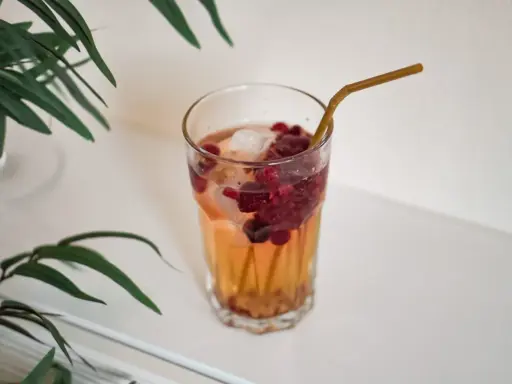Ett glas med hallonbladste, is och bär. Perfekt för en gravid som vill ha något uppfriskande.
