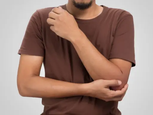Man håller om sin armbåge, där den mediala epikondylen kan kännas öm.