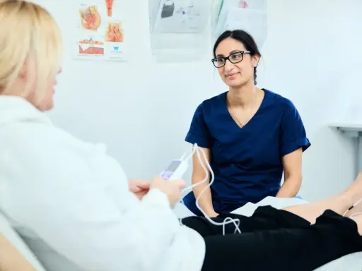 Läkare undersöker en patient med elektroder på benen. Bilden visar en situation där tjejer som kissar på sig kan få hjälp.