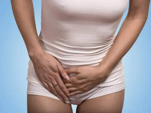 Kvinna håller handen över magen, upplever tidigt gravid ont i sidan av magen.