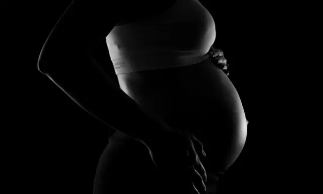 Silhuett av en gravid kvinna som håller sin mage. Bilden kan associeras med vena cava syndrom, en risk under graviditet.