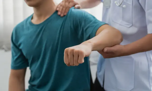 Läkare undersöker en patients arm, möjligen för att diagnostisera spricka i armbågen symtom.