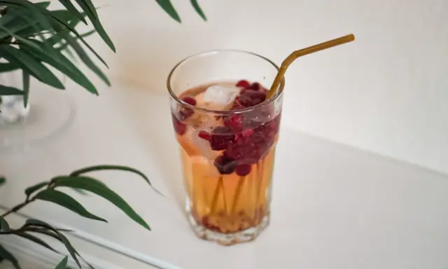 Ett glas med hallonbladste, is och bär. Perfekt för en gravid som vill ha något uppfriskande.