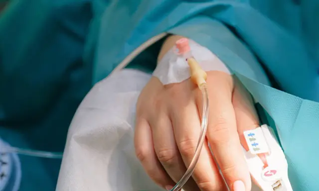 En hand med droppslang, en påminnelse om en misslyckad tvt-operation.