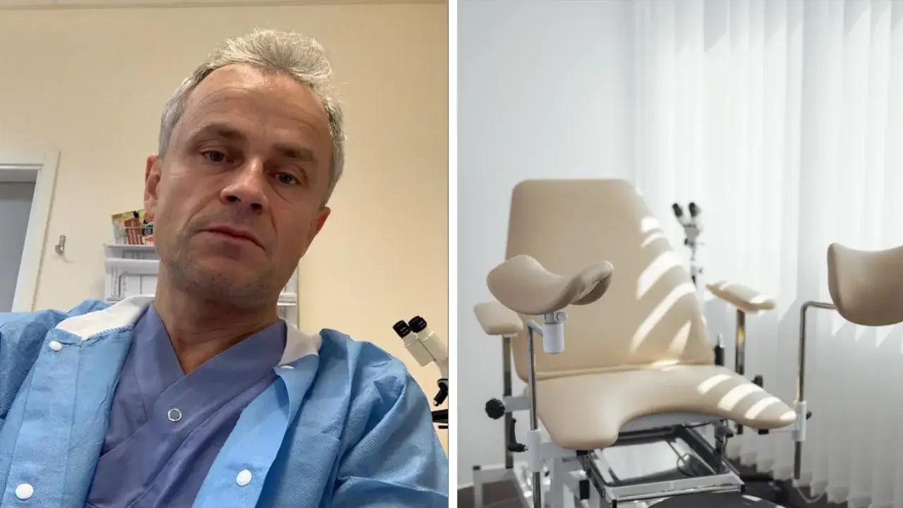 Manlig gynekolog i bl&aring; skyddsrock framf&ouml;r en gynekologstol.