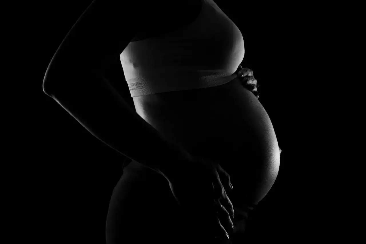 Gravid mage i silhuett. En hand vilar p&aring; magen, m&ouml;jligen f&ouml;r att lindra obehag relaterat till vena cava syndrom.